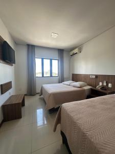 a hotel room with two beds and a window at Hotel Palace Frederico in Frederico Westphalen +17 photos
