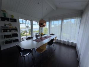 a dining room with a large white table and chairs at Beautiful pool villa with stunning ocean view in Tyresö
