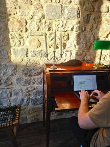 a man sitting at a desk with a laptop computer at Maestrale in Giovinazzo