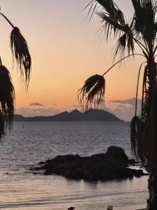 a sunset over the ocean with mountains in the background at Hotel Celta in Vigo