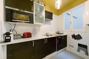 a kitchen with black cabinets and a microwave at Chez Emilien in Bordeaux