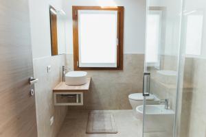 a bathroom with a sink and a toilet and a mirror at Villa Codetta Chalet Caterina in Boccatossa