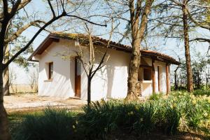 a small white house in the middle of trees at Villa Codetta Chalet Caterina in Boccatossa