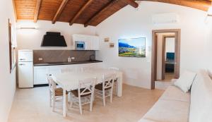 a kitchen and dining room with a white table and chairs at Villa Codetta Chalet Caterina in Boccatossa