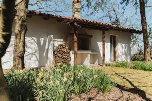 a small white house with flowers in front of it at Villa Codetta Chalet Caterina in Boccatossa +6 photos