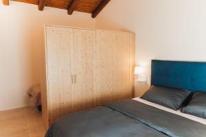 a bedroom with a bed and a wooden cabinet at Villa Codetta Chalet Caterina in Boccatossa