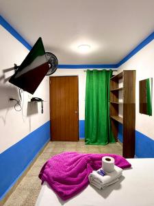 a room with a bed with a purple blanket and a lamp at Hotel Sol y Luna 2 in Medellín