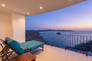 a balcony with a chair and a view of the ocean at Wake Up to the Pacific, Concierge Included in Playa Flamingo