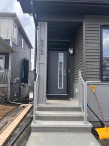 a gray house with a blue door and stairs at Slice Of Paradise in Calgary