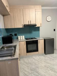 a kitchen with wooden cabinets and a stove and a sink at J&A Corner - Swakopmund in Swakopmund