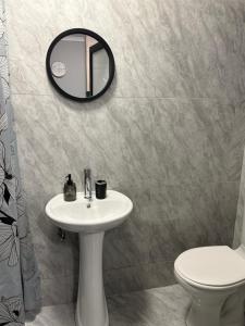 a bathroom with a sink and a mirror and a toilet at J&A Corner - Swakopmund in Swakopmund