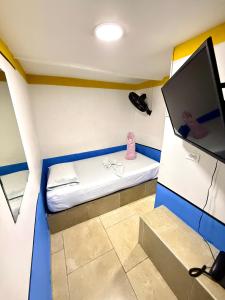 a small room with a bed and a flat screen tv at Hotel Sol y Luna 2 in Medellín