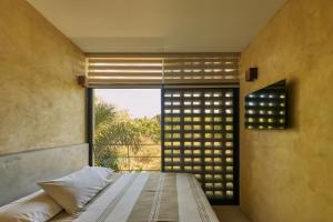 a bedroom with a bed and a large window at Casa Kame in Puerto Escondido