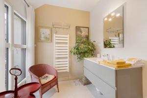 a bathroom with a sink and a mirror and a chair at Au Fil De L'eau - Chambre d'hôtes in Guipavas +17 photos