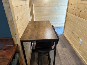 a wooden table and a chair in a room at Catch'em AK - Trout Haven in Soldotna