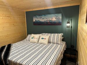 a bedroom with a bed and a painting on the wall at Catch'em AK - Trout Haven in Soldotna