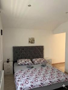 a bedroom with a bed with a red and white comforter at Apartman Gold LUX in Surčin