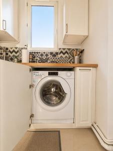 a washing machine in a kitchen with a window at Appartement 2 pieces cosy proche Paris et metro wifi rapide arrivee autonome in Asnières-sur-Seine +2 photos