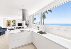a kitchen with white cabinets and a large window at Vista Roses Mar - Ancla Mar in Roses