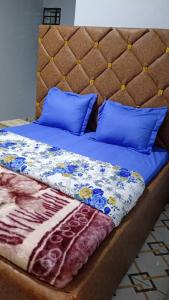 a bed with blue pillows and a blue comforter at SKY BLUE guest house in Buea