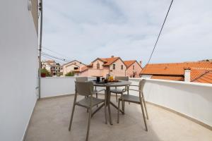 a table and chairs on a balcony with a view at Amare in Mali Lošinj
