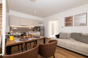 a kitchen and living room with a table and a couch at Amare in Mali Lošinj