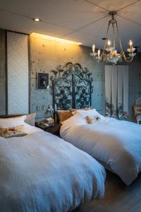 a bedroom with two beds and a chandelier at Penthouse KOKO in Miyakonojō
