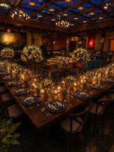 a long wooden table with candles and flowers on it at Casa de los Arcángeles in San Cristóbal de Las Casas +119 photos