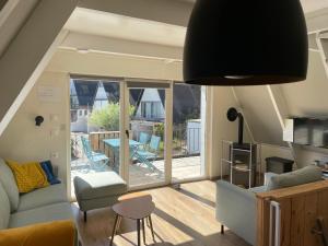 a living room with a couch and chairs and a patio at Maison des Dunes in Oostduinkerke