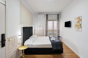 a white bedroom with a bed and a window at Mirosa Luxury Rooms in Pompei