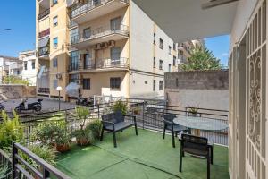 a balcony with a table and chairs and a building at Mirosa Luxury Rooms in Pompei