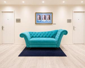 a blue couch in a room with two doors at Hotel Andante in Puebla