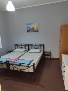 two twin beds in a room with a kitchen at comfortable room and shared kitchen and bathroom in Athens +8 photos
