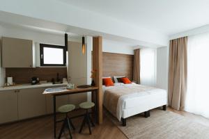 a bedroom with a bed and a desk and a kitchen at Gate67 in Otopeni