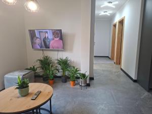 a living room with a table and a tv on the wall at Apartament 3 - OpolskieNoclegi in Krapkowice