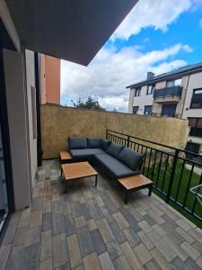 a blue couch sitting on a patio with two tables at Apartament 3 - OpolskieNoclegi in Krapkowice