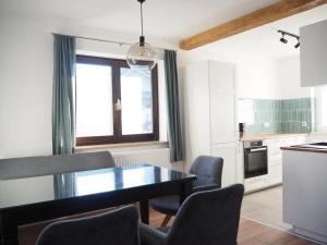 a kitchen with a dining room table and chairs at Ferienhaus mit Panoramablick in Ohlsdorf