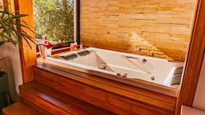 a bath tub in a bathroom with a window at Invernada Blessmann - Hotel Fazenda in Vespasiano Corrêa +47 photos