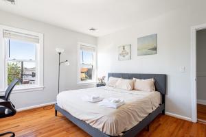 a bedroom with a bed with white walls and windows at Spacious 2BR-1BA-4 Beds NYC MetLife Parking in Bayonne