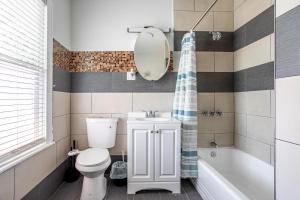 a bathroom with a toilet and a sink and a tub at Spacious 2BR-1BA-4 Beds NYC MetLife Parking in Bayonne