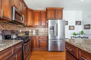 a kitchen with wooden cabinets and a stainless steel refrigerator at Spacious 2BR-1BA-4 Beds NYC MetLife Parking in Bayonne