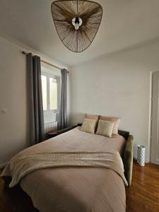 a bedroom with a large bed with a ceiling fan at L'Écrin Manceau Élégance, Sérénité & Confort in Le Mans