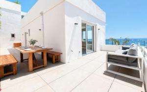 an outdoor patio with a wooden table and chairs at Vista Roses Mar - Ancla Mar in Roses
