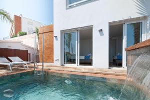 a swimming pool with a water feature next to a house at Vista Roses Mar - Ancla Mar in Roses