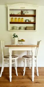 a white table and two chairs and a table and shelves at Heimat in Karstädt