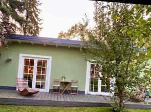 a green house with a table and chairs on a deck at Heimat in Karstädt