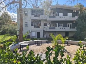 a large white building with picnic tables in front of it at Paradise studios in Nikiti