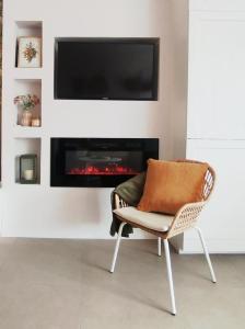 a chair in a living room with a fireplace at Szederinda házikó in Alsóörs