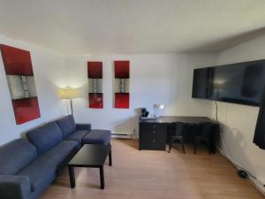 a living room with a blue couch and a table at Motel Grande Ile in Salaberry-de-Valleyfield