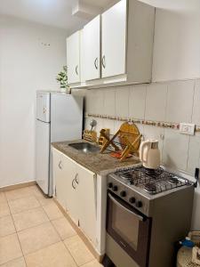 a kitchen with a stove and a sink and a refrigerator at Alojamiento En Resistencia Chaco in Resistencia